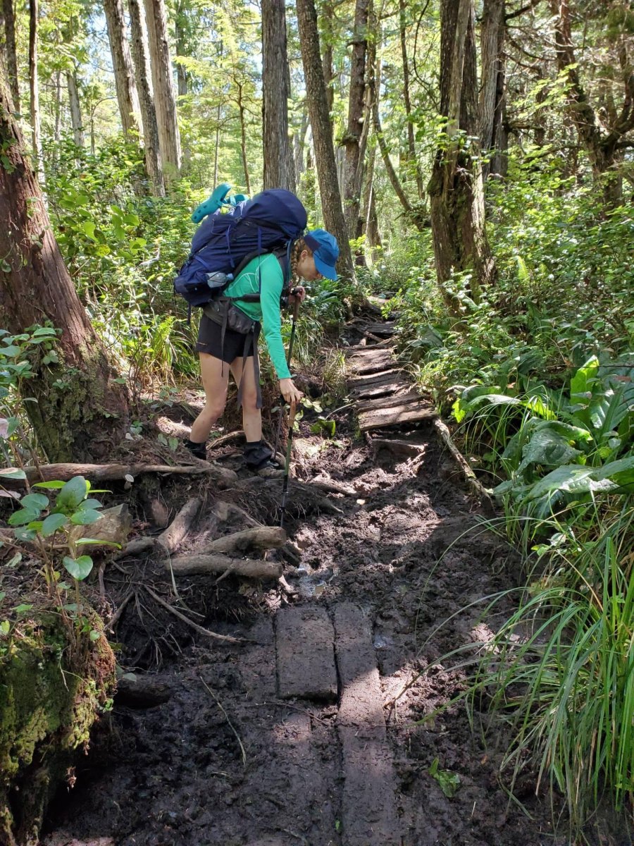 Hiker avoiding muddy trail