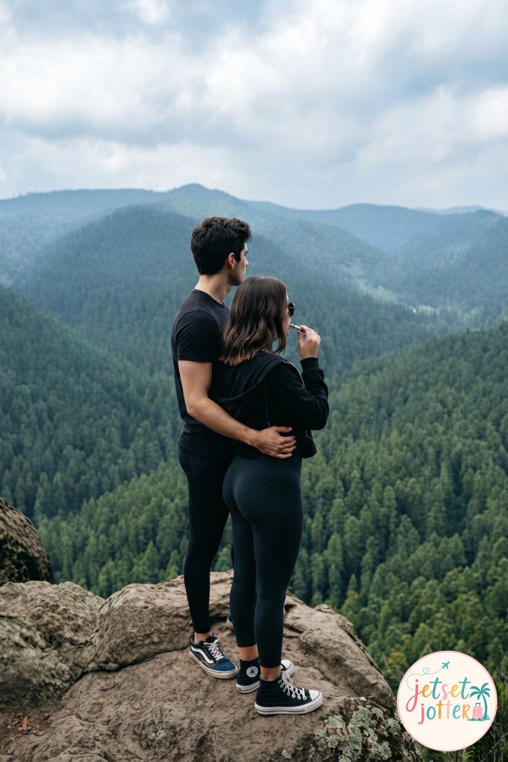 A simple hiking couple photo idea pointing toward distant peaks at a golden-lit viewpoint.
