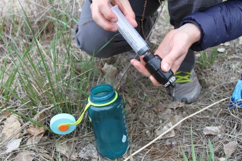 Cleaning backpacking water filter outdoors