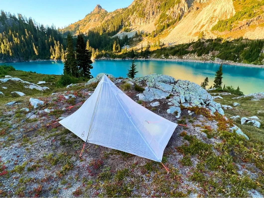 Ultralight backpacking checklist showing minimalist mountain shelter