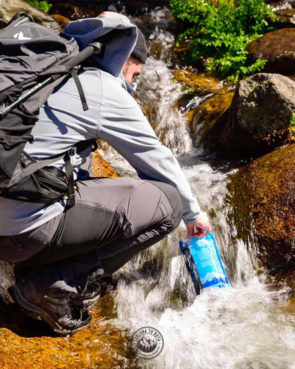 Hiker filtering stream water